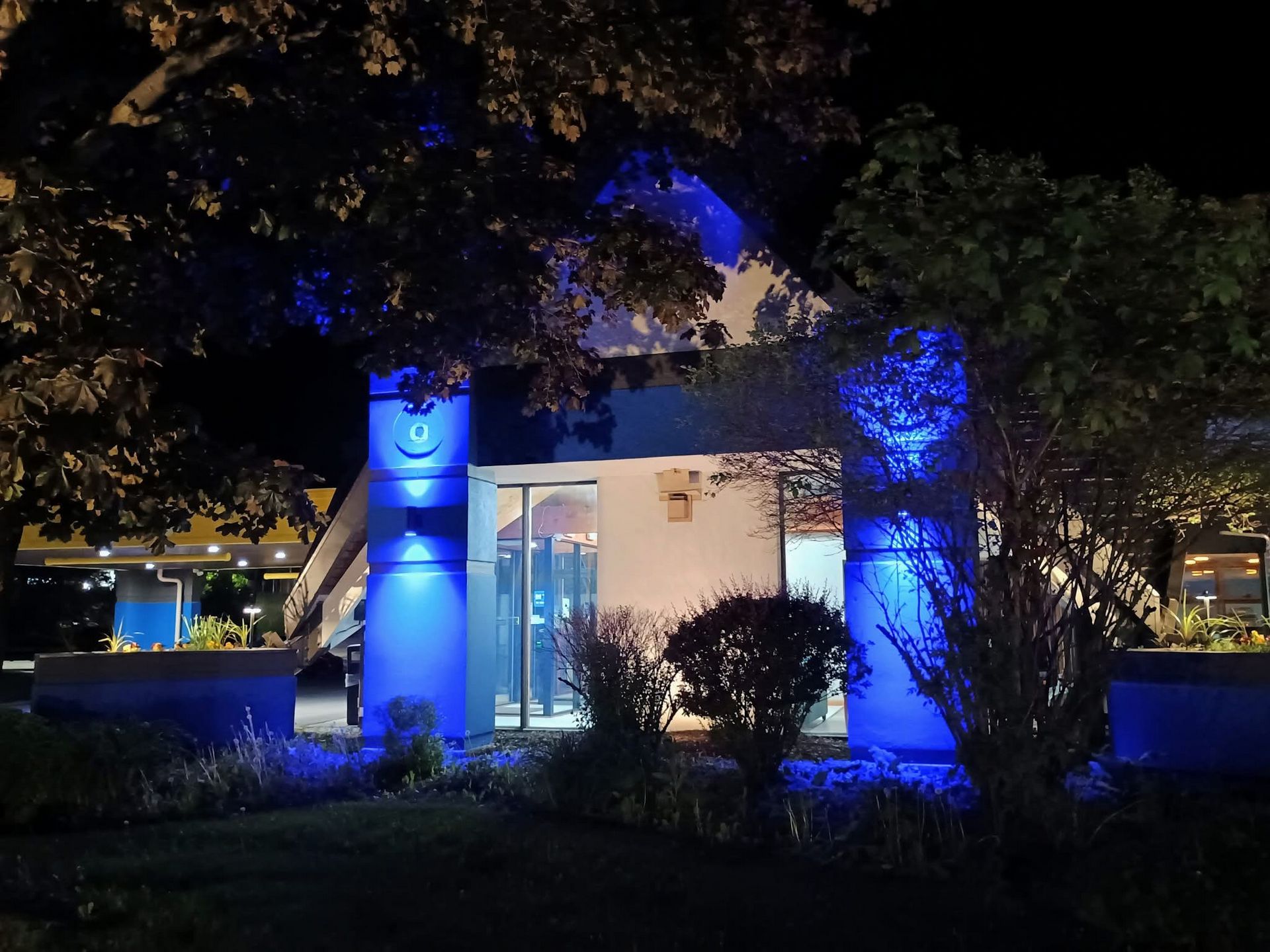 Days Inn Rutland Vermont 6/2025, you can see the canopy lighting retrofit LEDs to the back left and the low voltage lighting provided by "Sterling lighting" in big the flower containers.